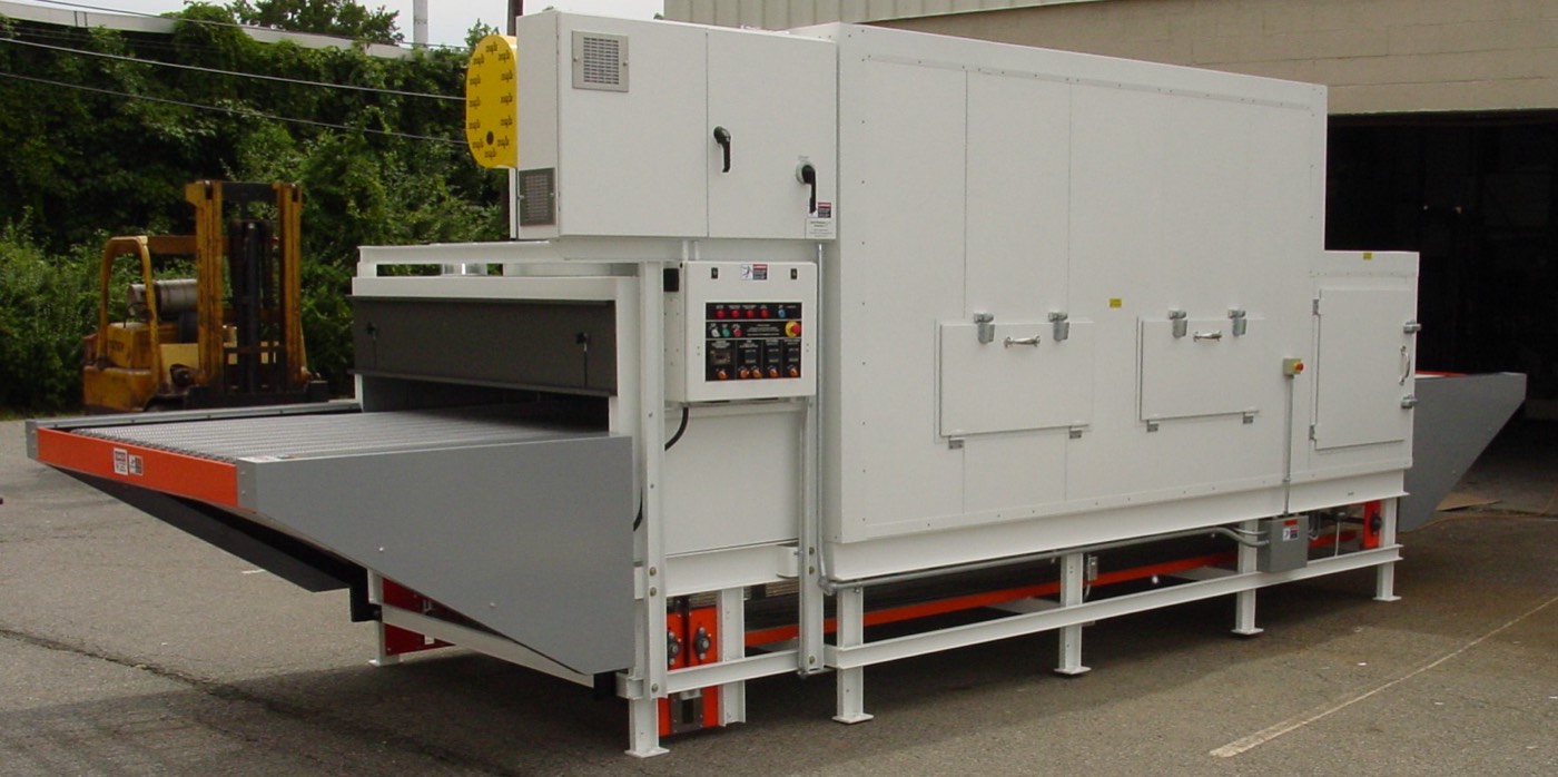 A conveyor-fed David Weisman industrial oven staged outside the shop